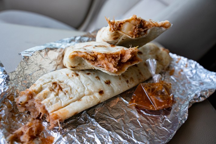 A trio of half eaten burritos.