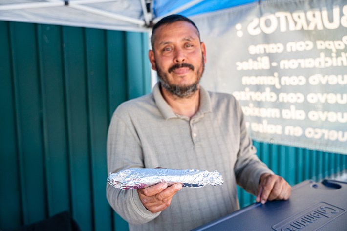 Jesus Mendoza holds up an aluminum wrapped burrito.