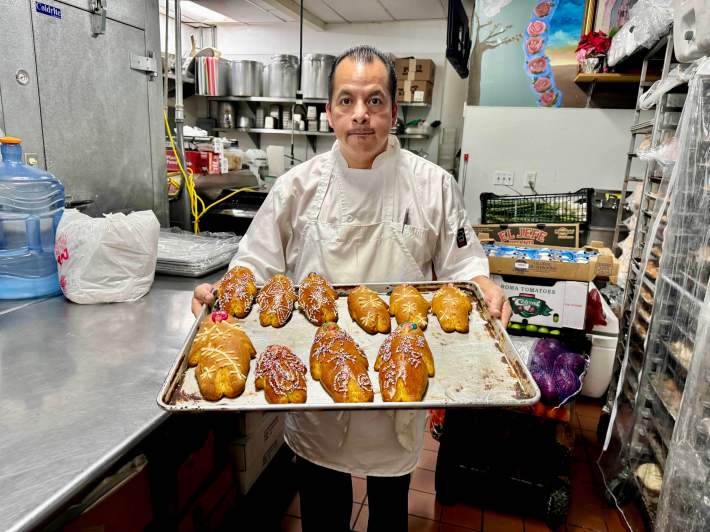 Sinecio Mecinas holding a tray of his pan de muerto at La Yalaltequita.